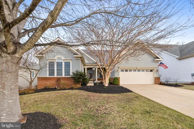 a front view of a house with a yard covered with snow