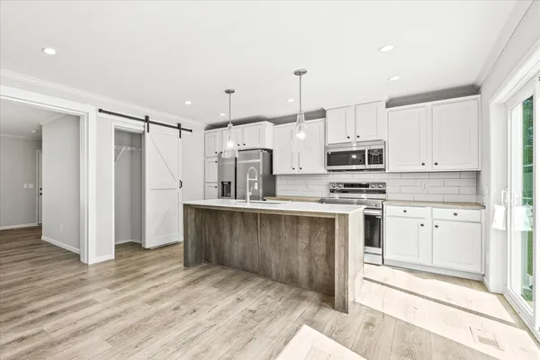 a kitchen with stainless steel appliances a refrigerator sink and microwave