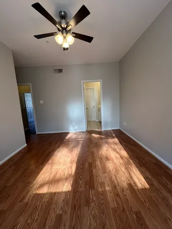 a view of empty room with wooden floor