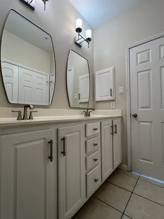 a bathroom with 2 sink and a mirror