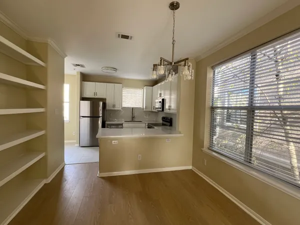 a view of kitchen with stainless steel appliances granite countertop a stove and a refrigerator