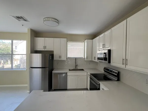 a kitchen with stainless steel appliances a refrigerator sink and microwave