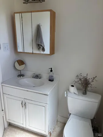 a bathroom with a toilet sink and mirror