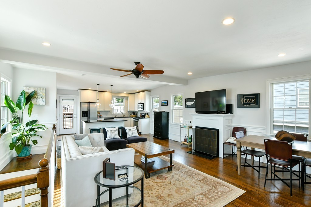 a living room with furniture a fireplace a flat screen tv and potted plant