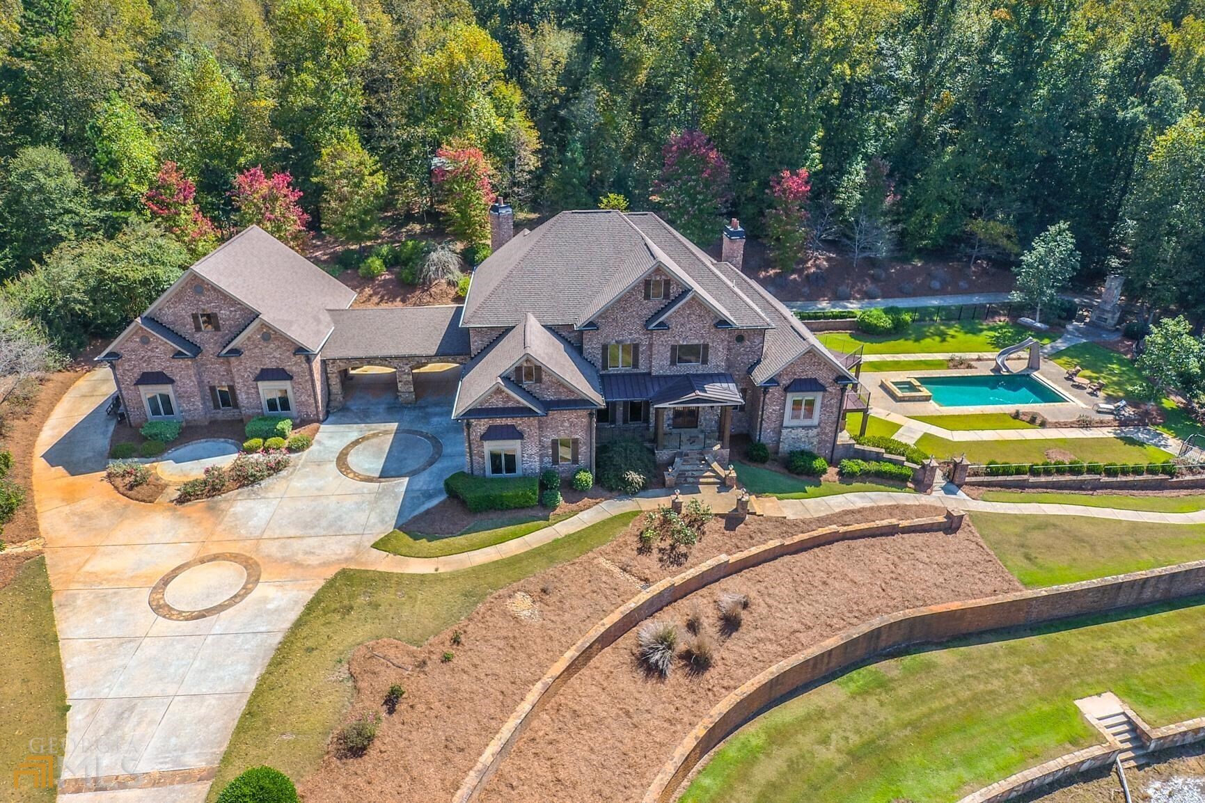 an aerial view of a house with swimming pool and garden