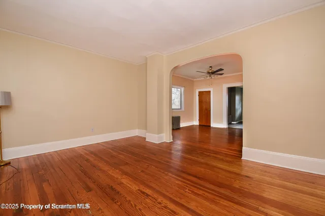 a view of empty room with wooden floor