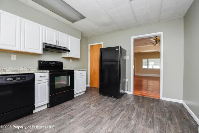 a kitchen with granite countertop wooden cabinets and stainless steel appliances