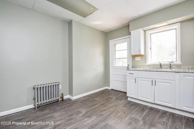 a view of a kitchen with wooden floor and electronic appliances