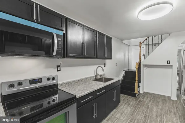 a kitchen with granite countertop a stove and a microwave