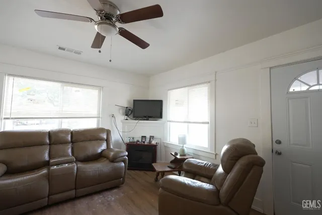 a living room with furniture a flat screen tv and a window