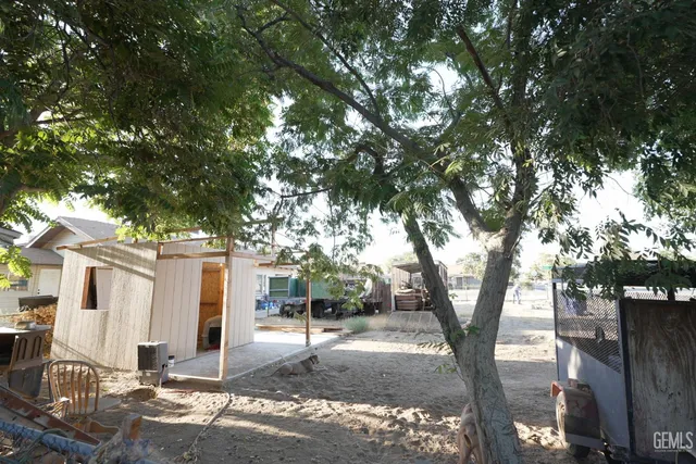a backyard of a house with barbeque oven and outdoor seating