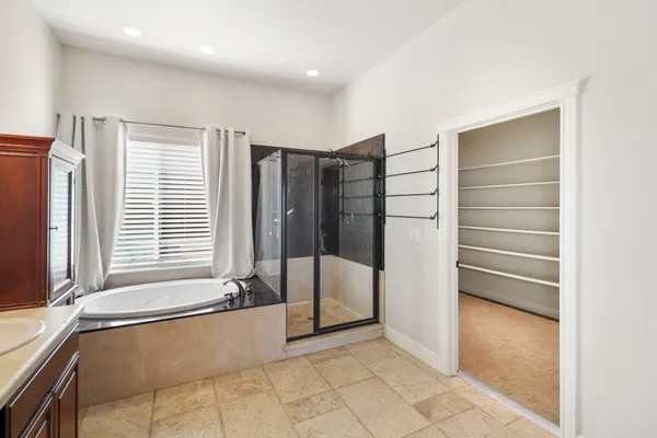 a spacious bathroom with a double vanity sink a large mirror and a toilet