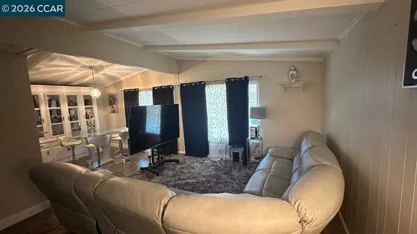 a large living room with stainless steel appliances kitchen island granite countertop furniture and a living room