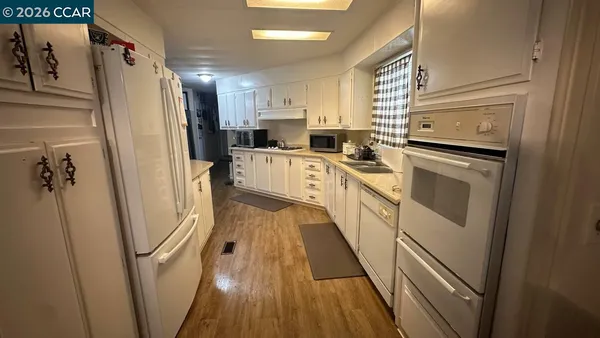 a kitchen with stainless steel appliances a refrigerator sink and white cabinets