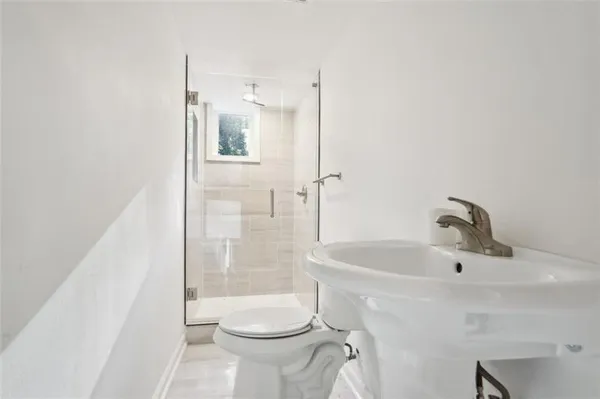 a bathroom with a sink a toilet and shower