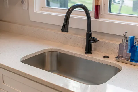 a kitchen with a sink a microwave a refrigerator and cabinets