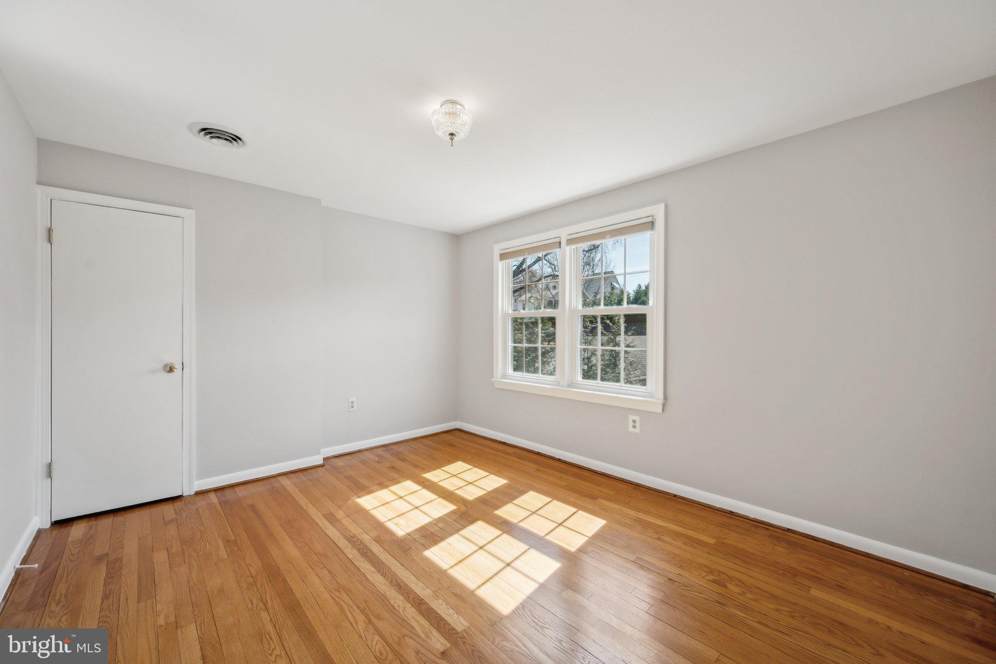 1720 Dublin Drive Silver Spring, MD 20902 - Photo 22 of 34 a view of an empty room with wooden floor and a window
