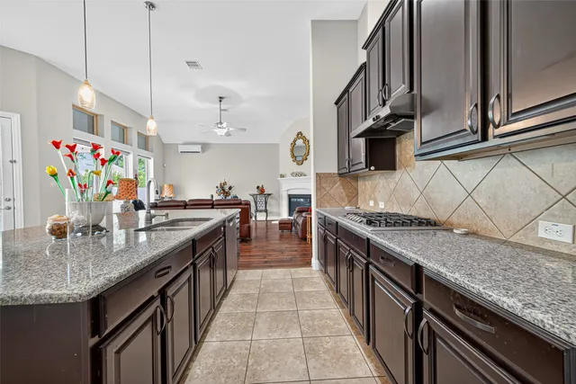 a kitchen with granite countertop a table chairs and chandelier
