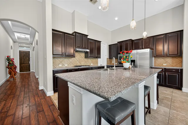 a kitchen with refrigerator and chairs