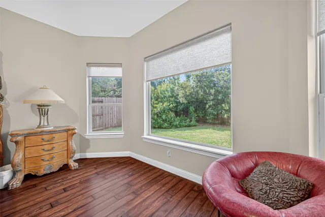 a bedroom with a bed wooden floor and window