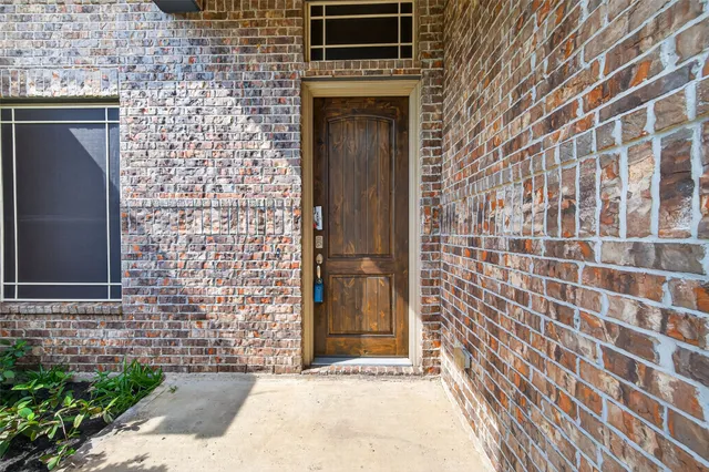 a view of hallway with window and wooden floor