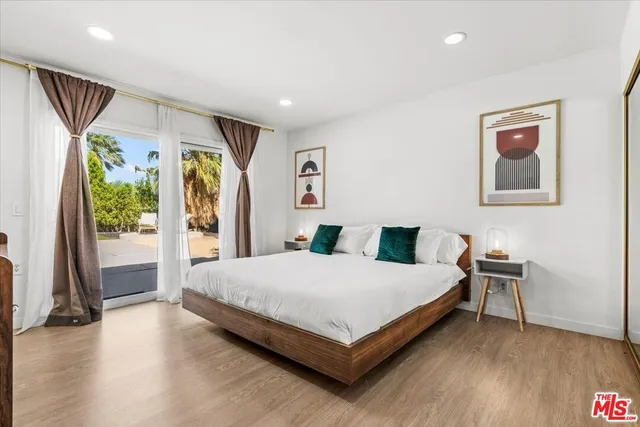 a large bedroom with a bed and wooden floor