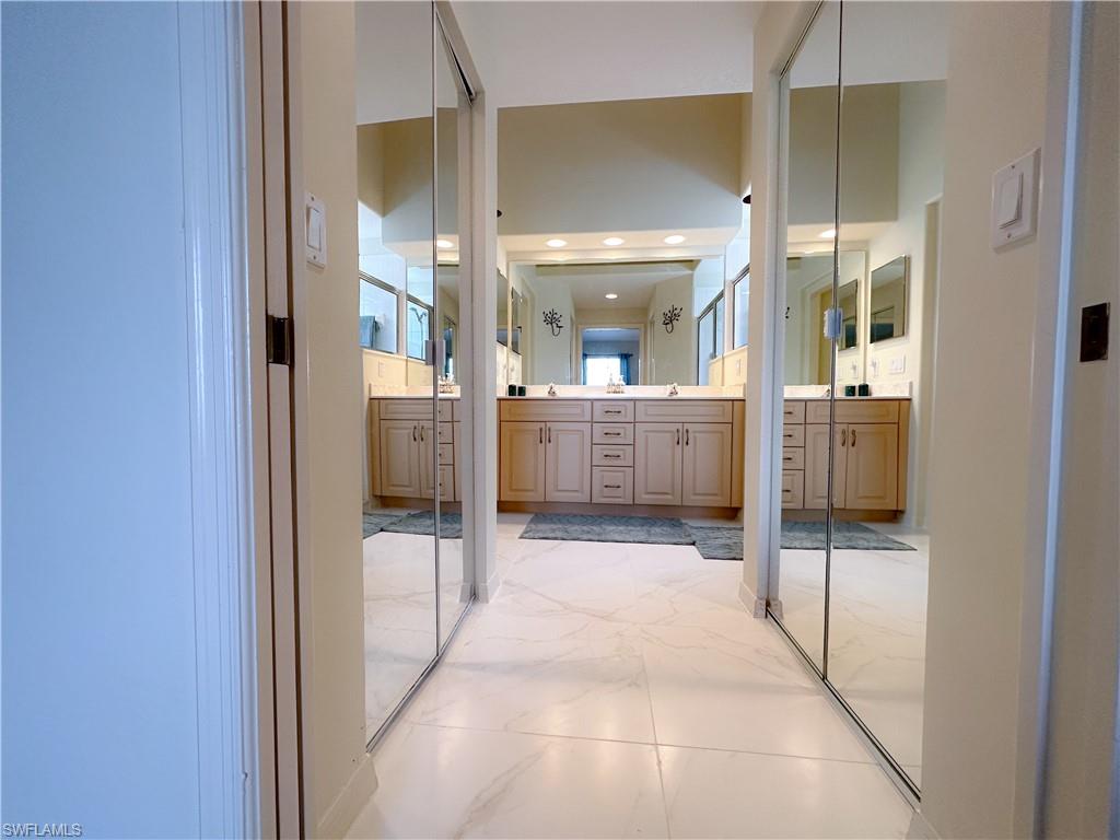 8220 Ibis Cove Circle, Unit B216 Naples, FL 34119 - Photo 11 of 34 a bathroom with a glass shower door and mirror