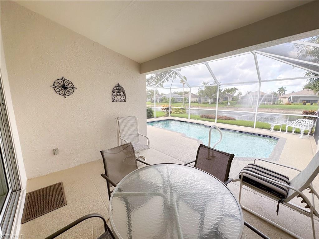 8220 Ibis Cove Circle, Unit B216 Naples, FL 34119 - Photo 14 of 34 a living room with furniture and a floor to ceiling window