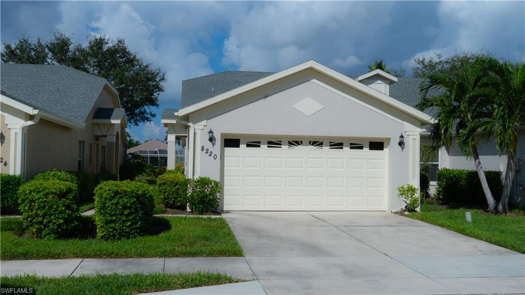 8220 Ibis Cove Circle, Unit B216 Naples, FL 34119 - Photo 32 of 34 a view of a white house with a small yard and plants