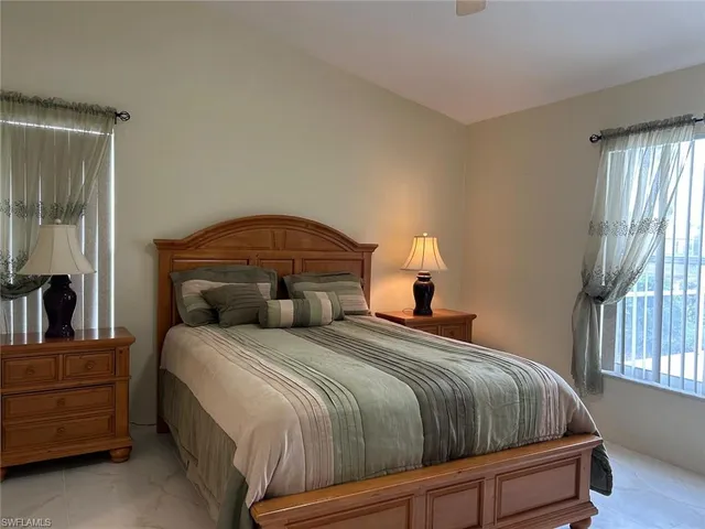 a bedroom with a bed a window and dresser