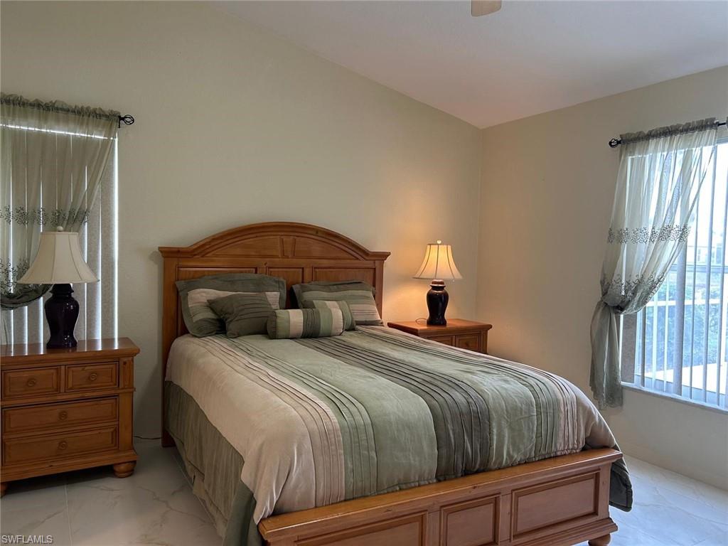 8220 Ibis Cove Circle, Unit B216 Naples, FL 34119 - Photo 10 of 34 a bedroom with a bed a window and dresser