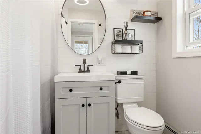 a bathroom with a toilet a sink and a mirror