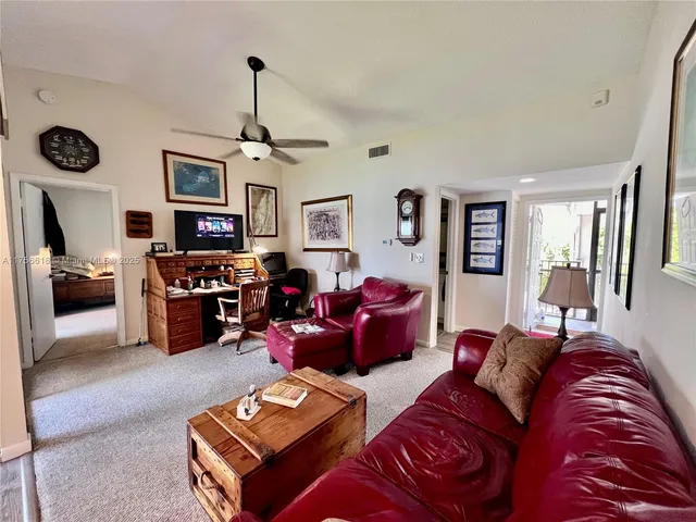 a living room with furniture kitchen view and a window
