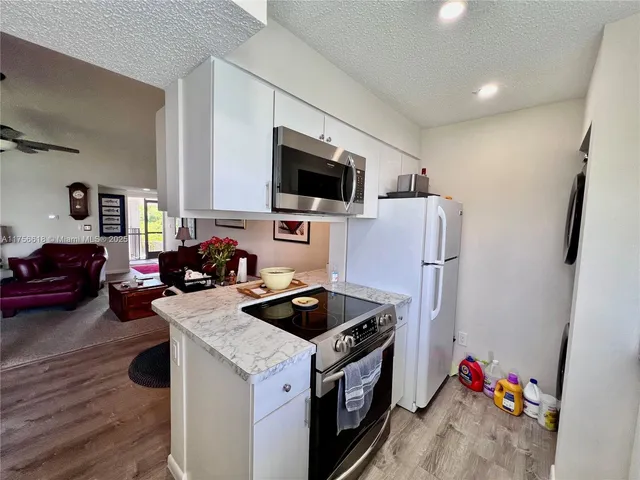 a kitchen with white cabinets and sink