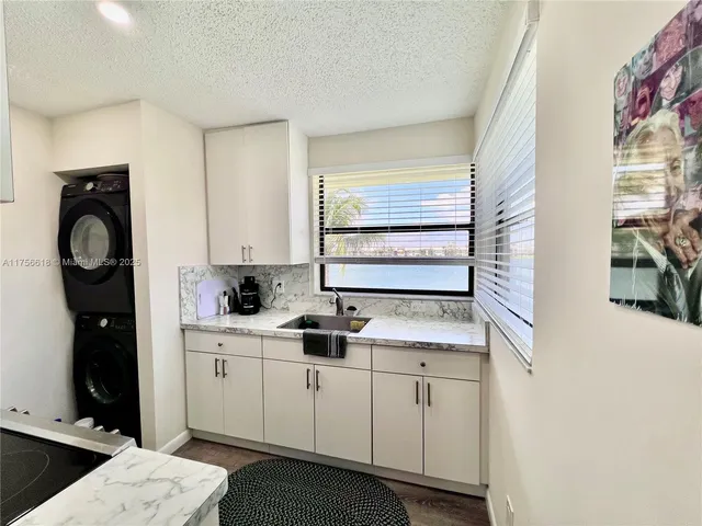 a kitchen with granite countertop a refrigerator and a sink