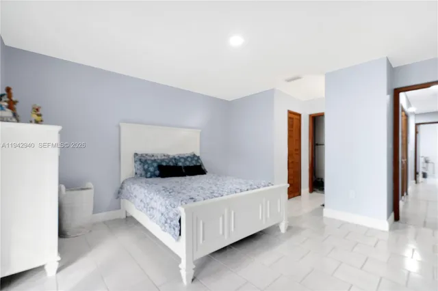 a bedroom with a bed and a refrigerator