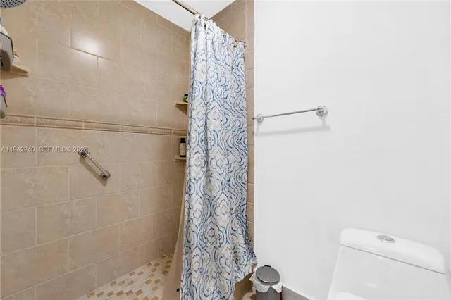 a bathroom with a shower curtain and a toilet