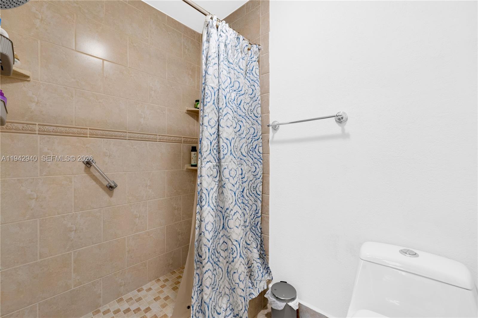 1142 Southwest 138th Court Miami, FL 33184 - Photo 25 of 50 a bathroom with a shower curtain and a toilet