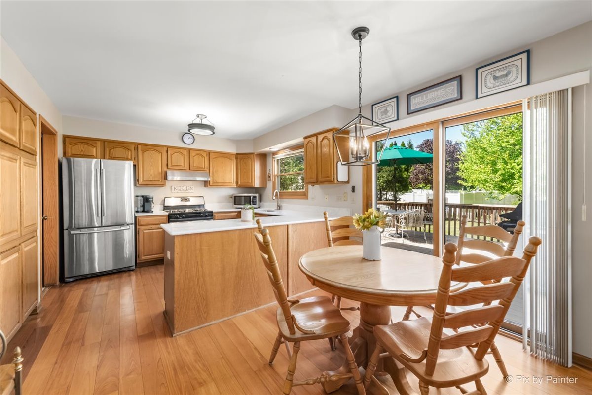 121 Hampton Street Cary, IL 60013 - Photo 14 of 56 a kitchen with stainless steel appliances granite countertop a refrigerator a oven a sink a dining table and chairs with wooden floor