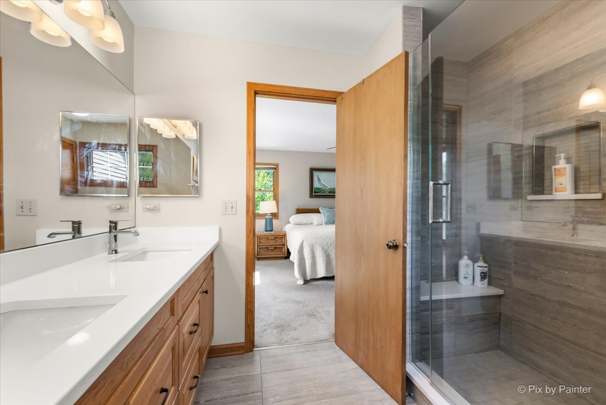121 Hampton Street Cary, IL 60013 - Photo 30 of 56 a en suite bathroom with a double vanity sink a mirror and a shower