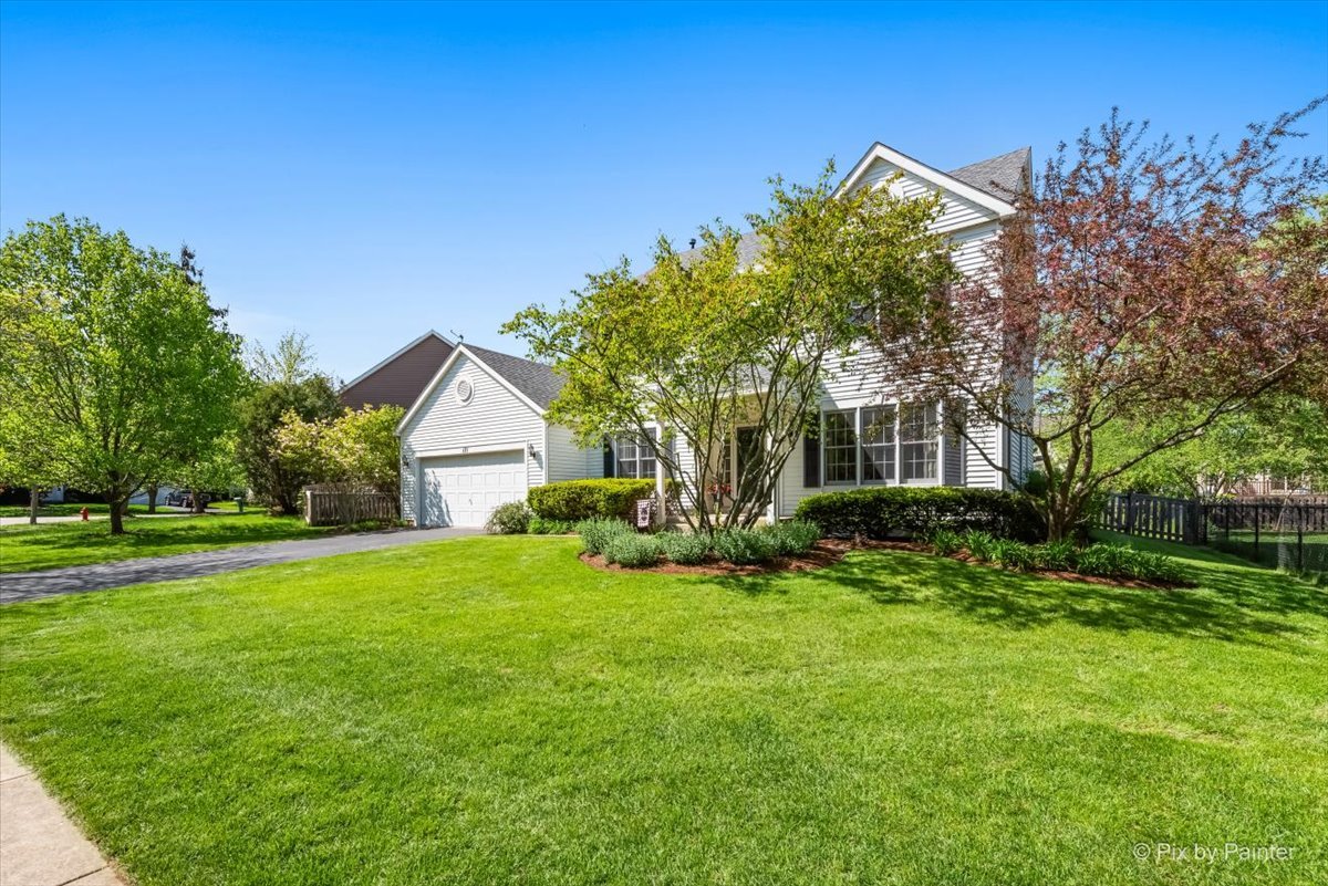 121 Hampton Street Cary, IL 60013 - Photo 3 of 56 a front view of a house with a yard and trees