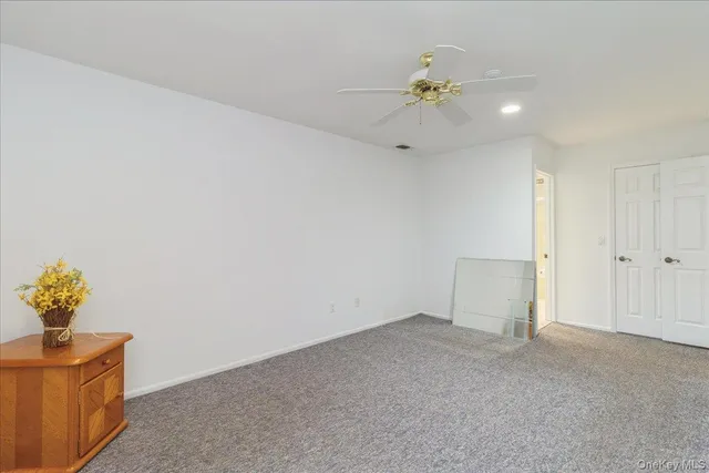 a view of an empty room and a chandelier fan