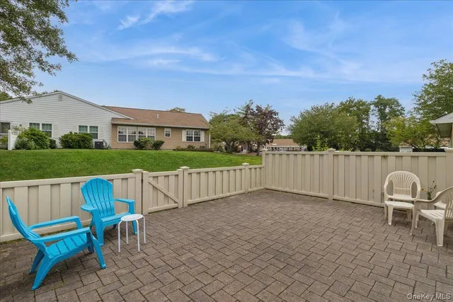 a view of a chairs and table in the back yard of the house