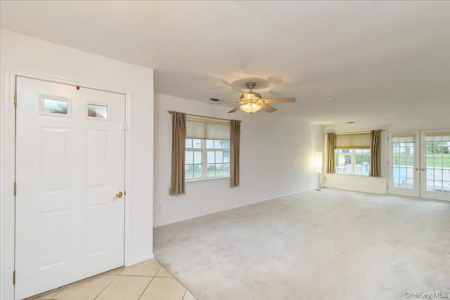 an empty room with windows and chandelier