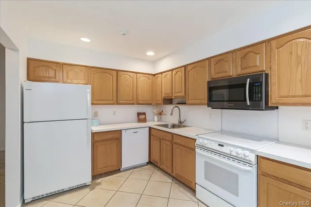 a kitchen with a sink a white cabinets and white appliances