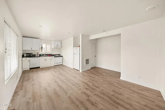 a view of kitchen with wooden floor and electronic appliances