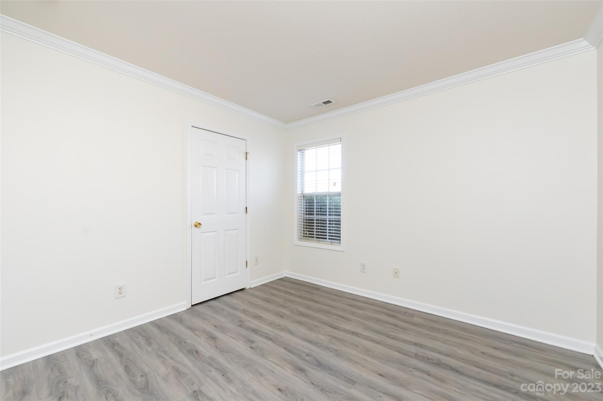 13009 Beddingfield Drive Charlotte, NC 28278 - Photo 23 of 32 an empty room with wooden floor and windows