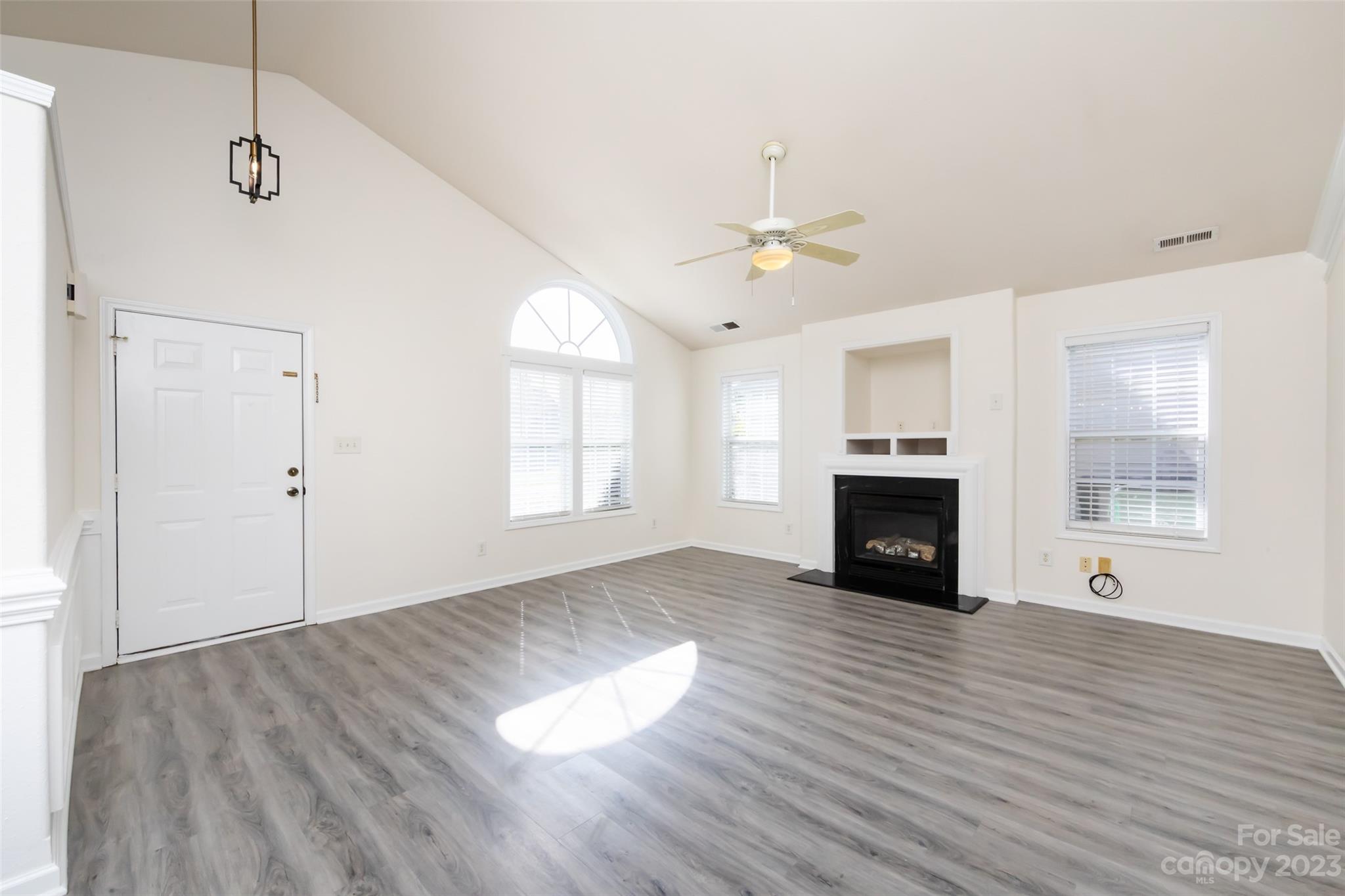 13009 Beddingfield Drive Charlotte, NC 28278 - Photo 5 of 32 an empty room with wooden floor fireplace and windows