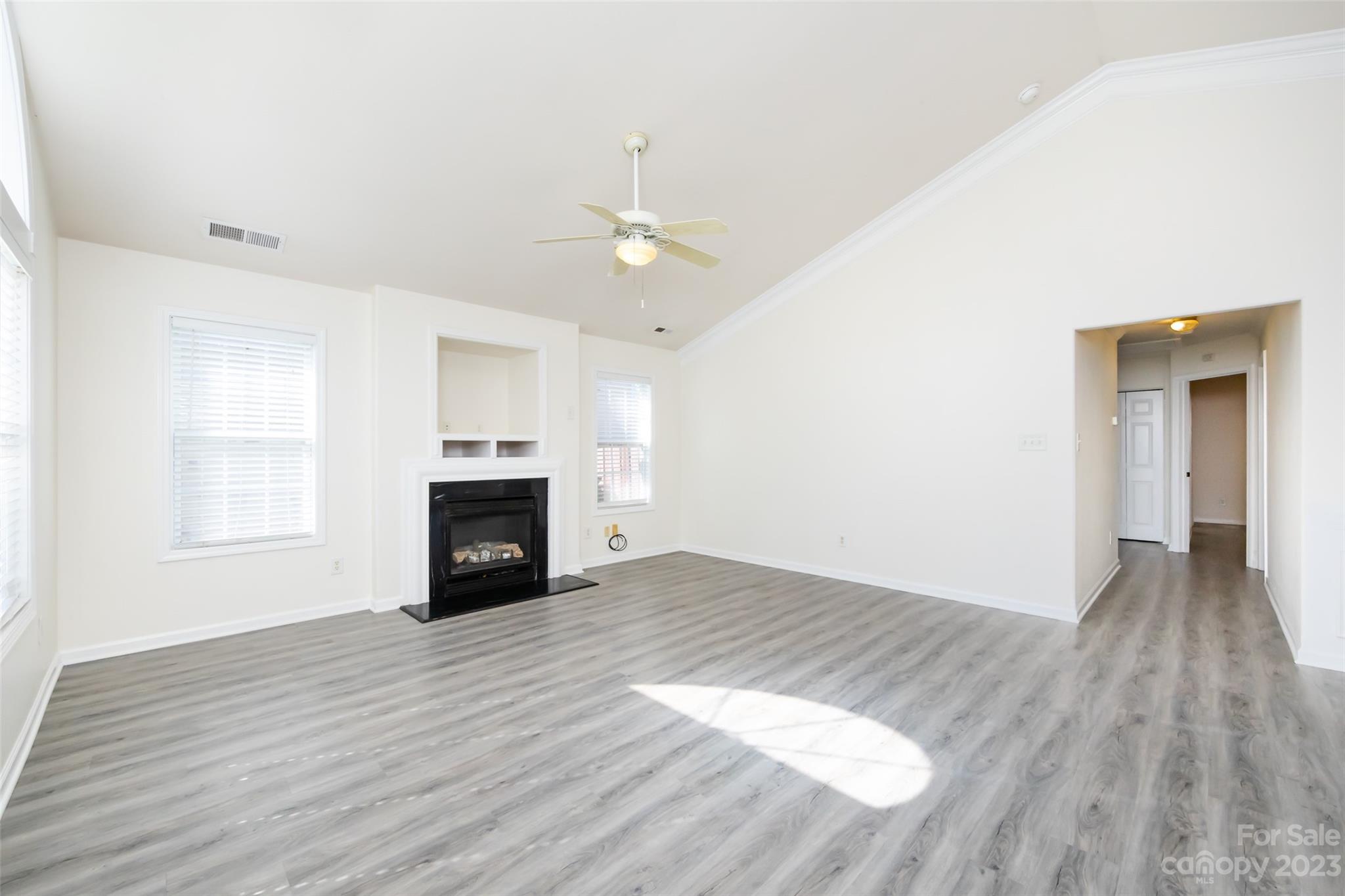 13009 Beddingfield Drive Charlotte, NC 28278 - Photo 6 of 32 an empty room with wooden floor fireplace and windows