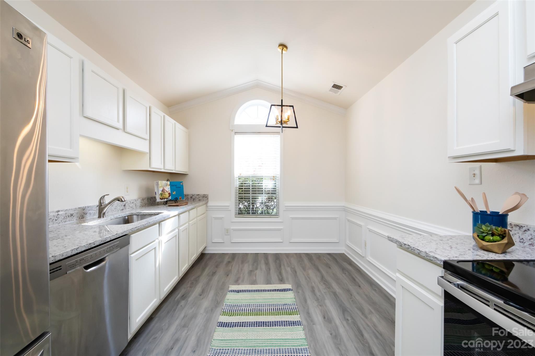 13009 Beddingfield Drive Charlotte, NC 28278 - Photo 10 of 32 a kitchen with kitchen island granite countertop stainless steel appliances a stove a sink and white cabinets with wooden floor
